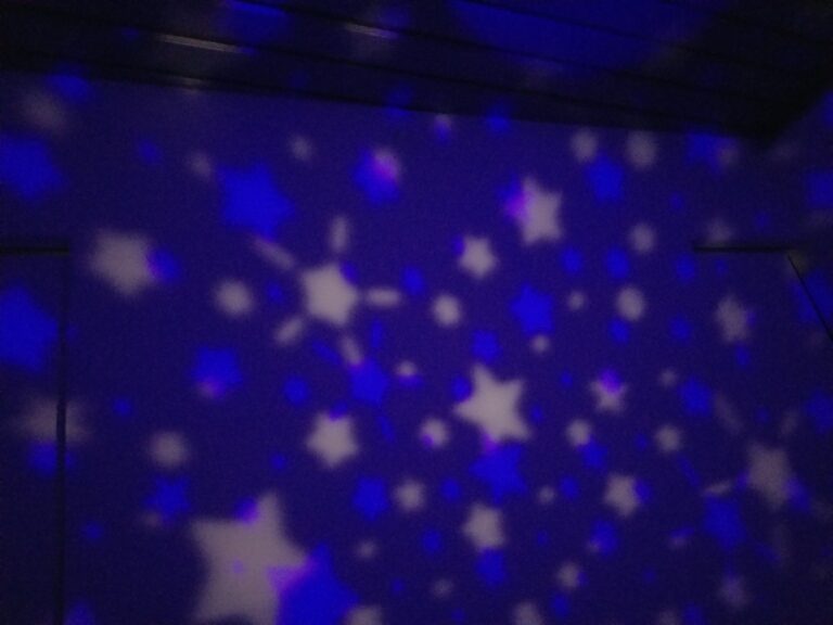 A wall with stars being projected onto it