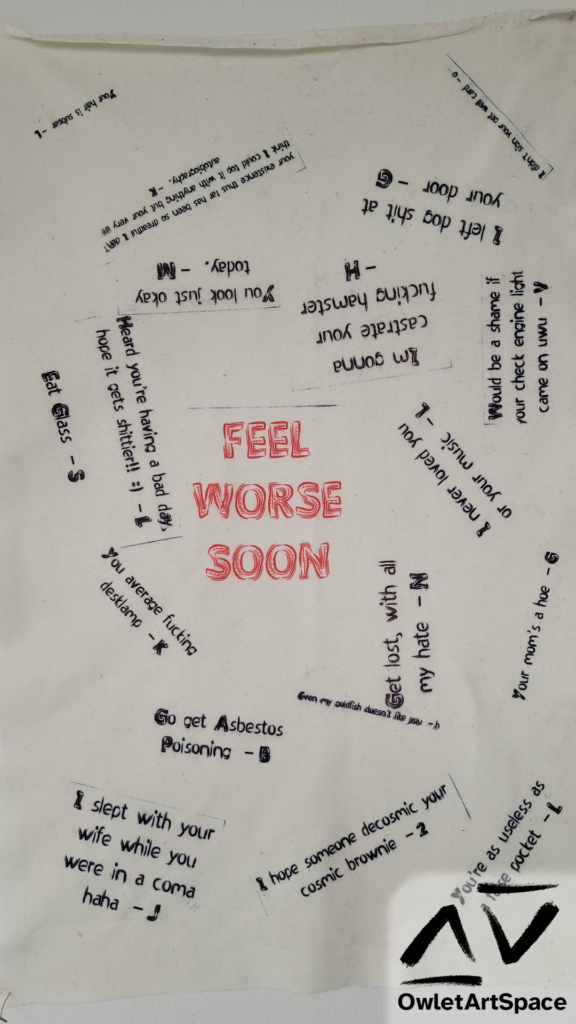 A sheet of fleece pinned onto the wall with the words "Feel Worse Soon" in red in the center. Around it are megative and insulting phrases responding to the viewer, with lines such as "Go get Asbestos Poisoning", "Get lost, with all my hate", and "I slept with your wife while you were in a coma haha"