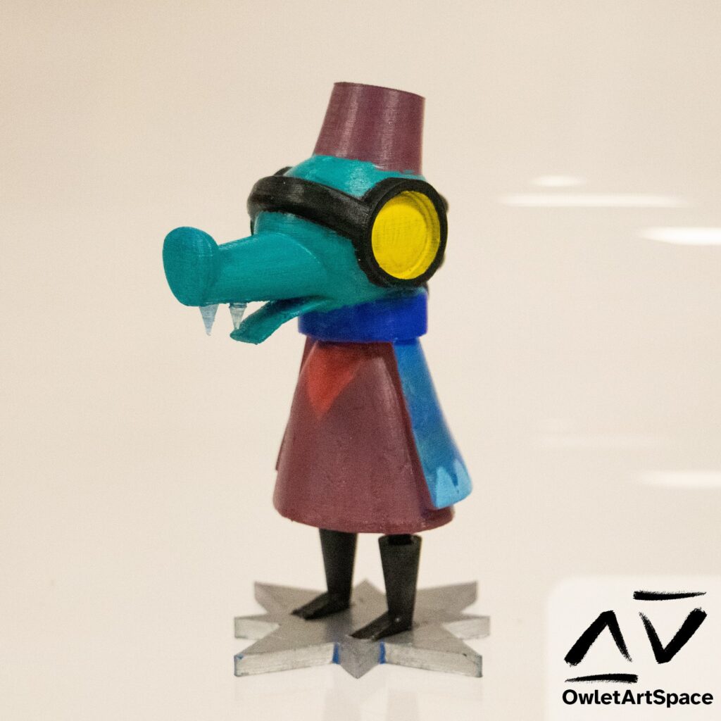Adina Astra from the game Night In The Woods. They are a teal anthropomorphized crocodile, They have two front teeth. They wear goggles which glow yellow. There are three spines on the back of their head. They are wearing a fez without the tassle. They wear a dark navy cape with light blue triangles on the bottom on top of a red coat. This is the 3D printed model shown from a 45 degre angle facing forwards.