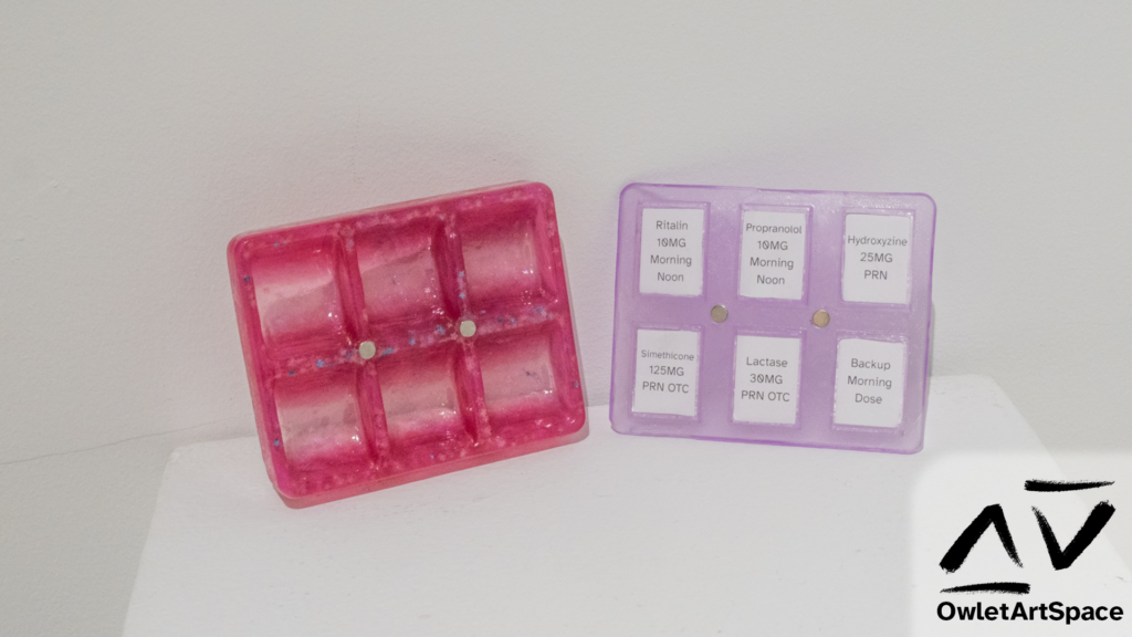 Both halves of the Medbox. On the left is the base. A red star-glittered box with six indents and two magnets on the front facing side. On the left a purple glittery lid with six labels stating names for different medications, also with two magnets.