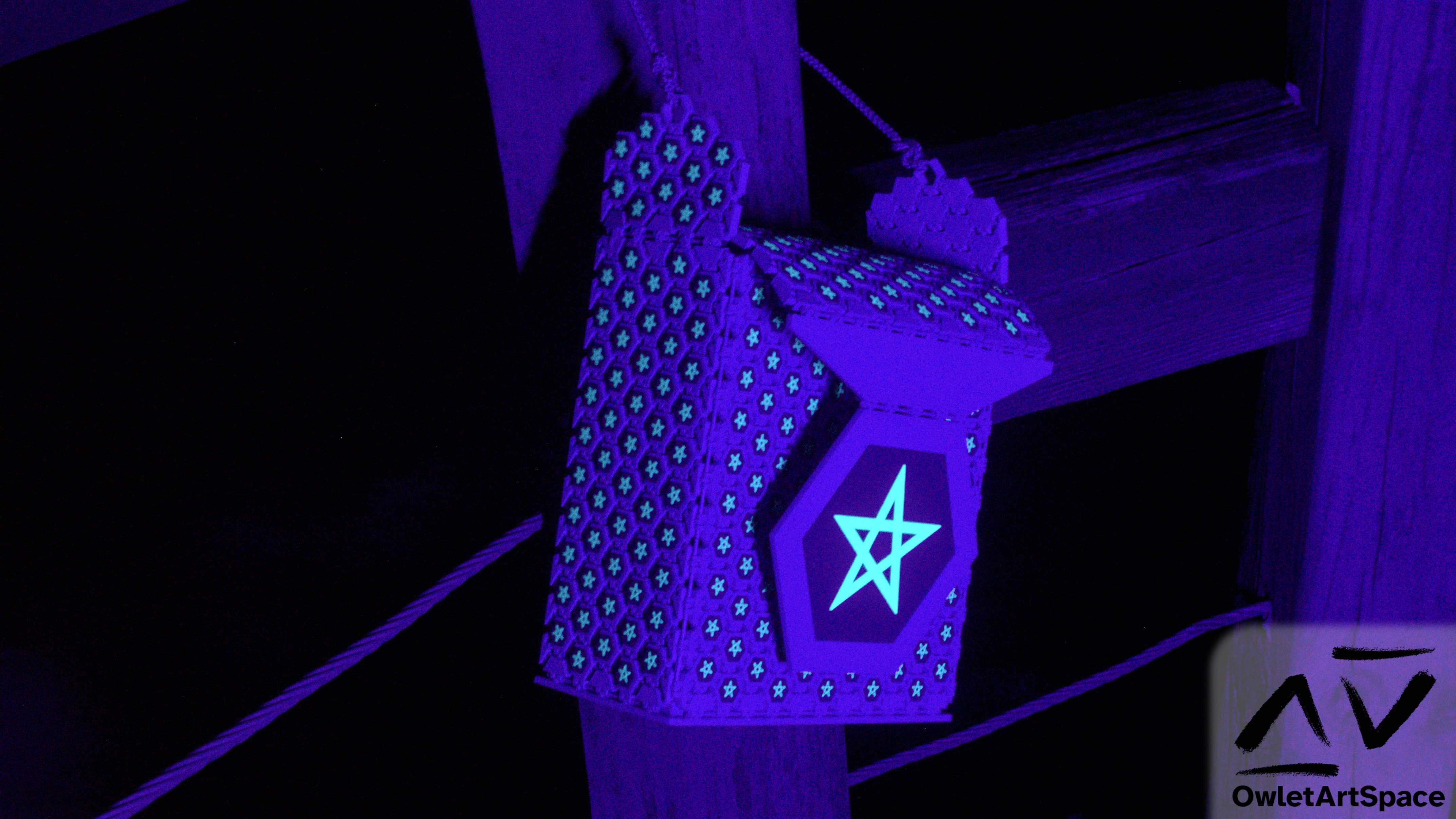 The starry bag under UV light hanging off of a post.